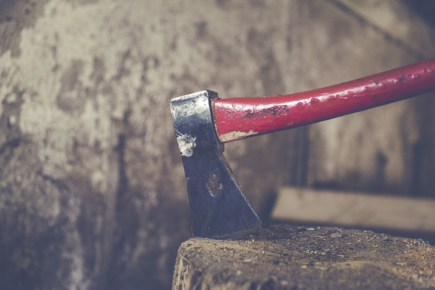 Red Hatchet Embedded in Wood Log