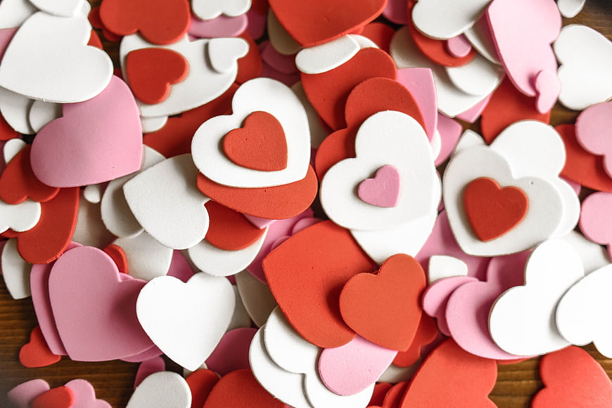 Scattered Red, Pink, and White Foam Hearts on Wood