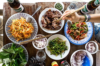 Overhead view of Vietnamese feast with grilled meat and papaya salad