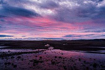 Dramatic Pink and Purple Sunset Over Rocky Beach