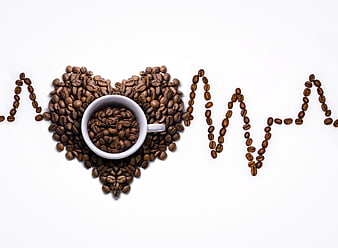 Coffee beans arranged in heart and heartbeat line on white background
