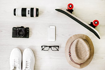 Flat Lay of Travel Accessories, Camera, Skateboard, and Sneakers