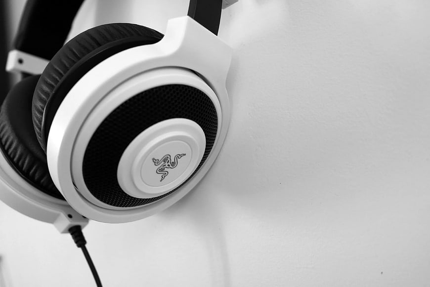 Close-up of white and black gaming headphones on white wall