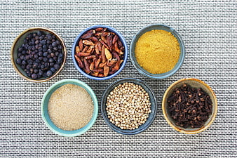 Top View of Assorted Spices in Ceramic Bowls on Textured Mat