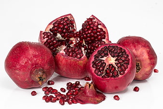 Fresh Red Pomegranates with Seeds on White Background