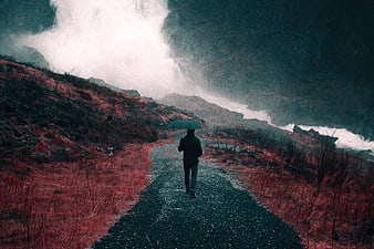Lone figure with umbrella on misty mountain path