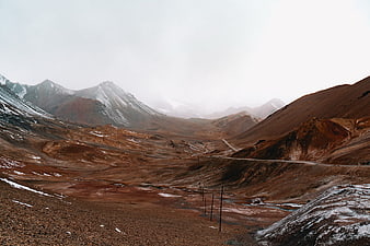 Desolate Mountain Landscape with Winding Road and Snow