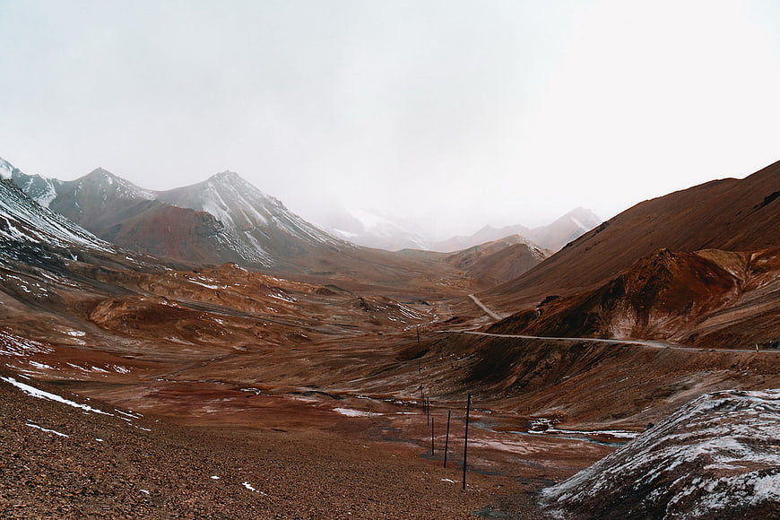 Desolate Mountain Landscape with Winding Road and Snow