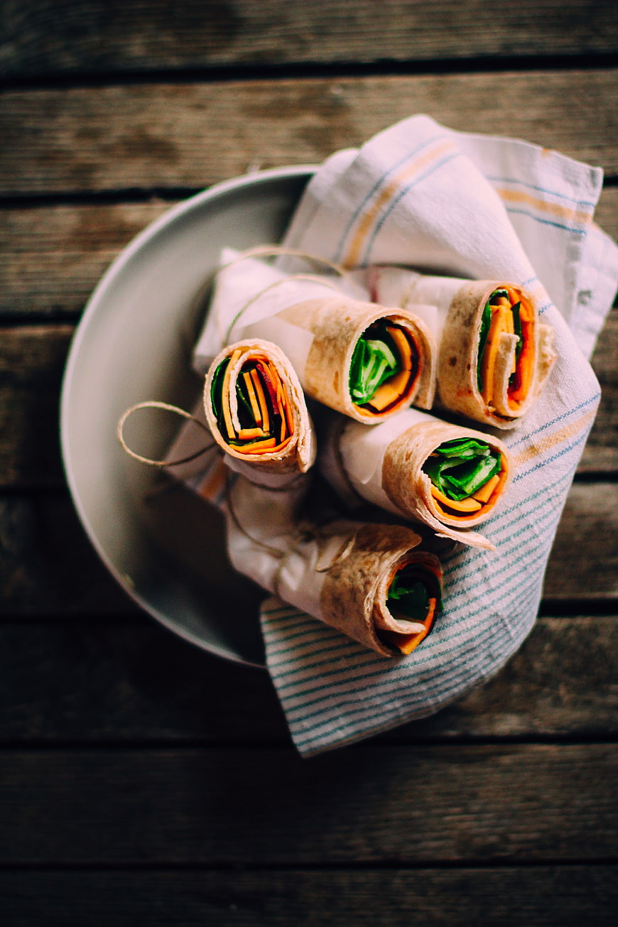 Healthy vegan wraps with vegetables on rustic wooden table
