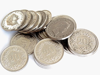 Pile of silver Swiss 20 centime coins on a white background