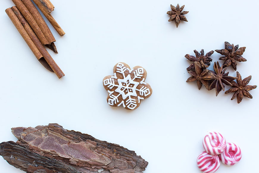 Flat lay of gingerbread snowflake cookie with cinnamon and spices