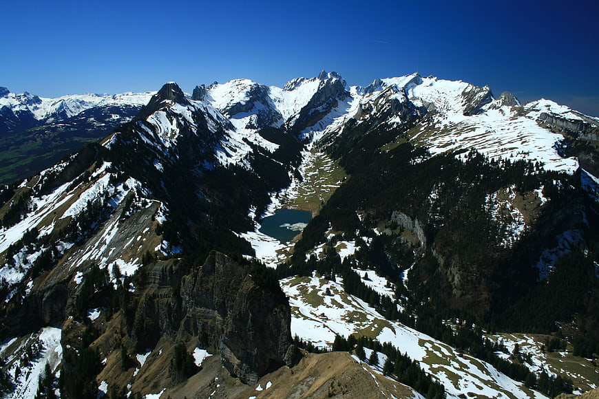 Snowy mountain peaks with alpine lake and blue sky