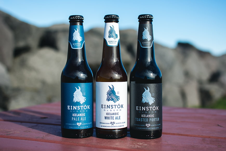 Three bottles of Icelandic craft beer on a wooden table outdoors