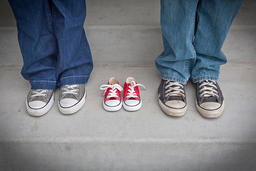 Family sneakers on concrete steps with baby shoes