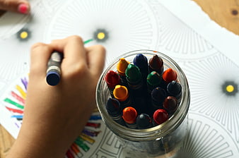 Child Coloring with Crayons on Mandala Pattern
