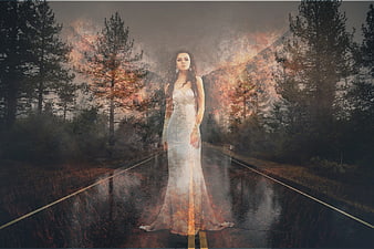 Ethereal woman in white dress superimposed on burning forest road