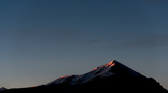 Alpenglow on Snow-Capped Mountain Peak at Dusk
