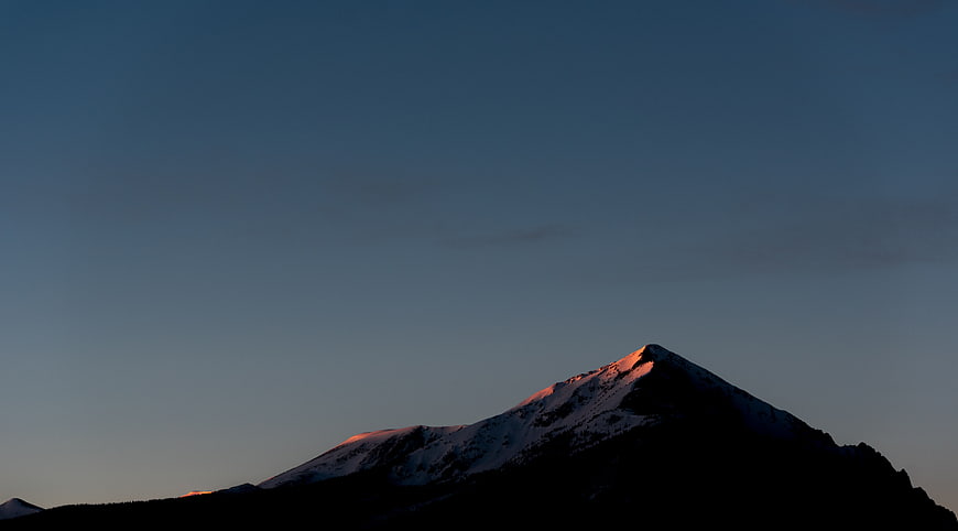 Alpenglow on Snow-Capped Mountain Peak at Dusk