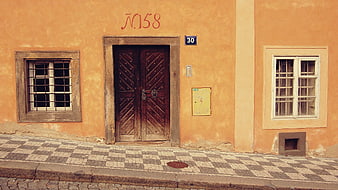 Old Orange Building Facade with Wooden Door and Cobblestone Street