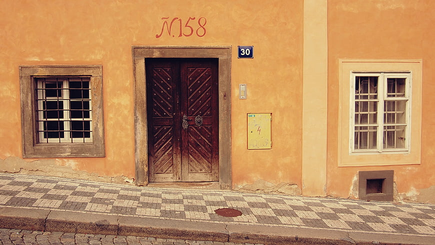 Old Orange Building Facade with Wooden Door and Cobblestone Street