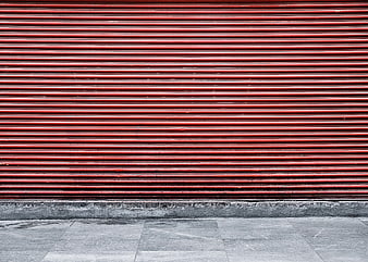 Red metal shutter door on urban street background