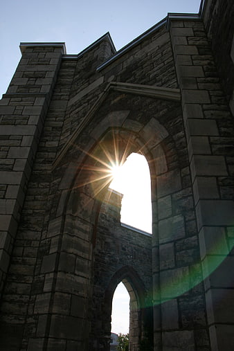 Sunburst Through Stone Arch of Historic Church Ruins