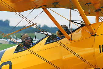 Two Pilots in Vintage Yellow Biplane Cockpit