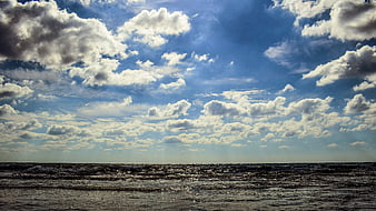 Dramatic Seascape with Cloudy Blue Sky and Choppy Ocean Waves