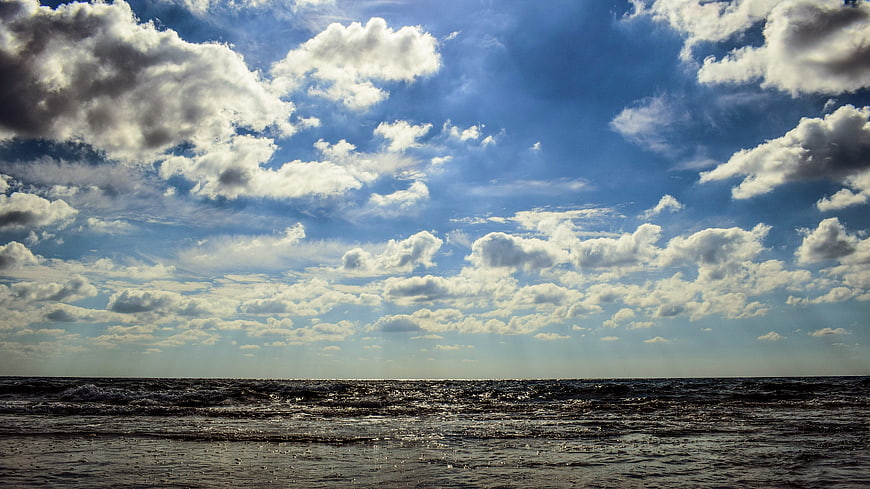 Dramatic Seascape with Cloudy Blue Sky and Choppy Ocean Waves