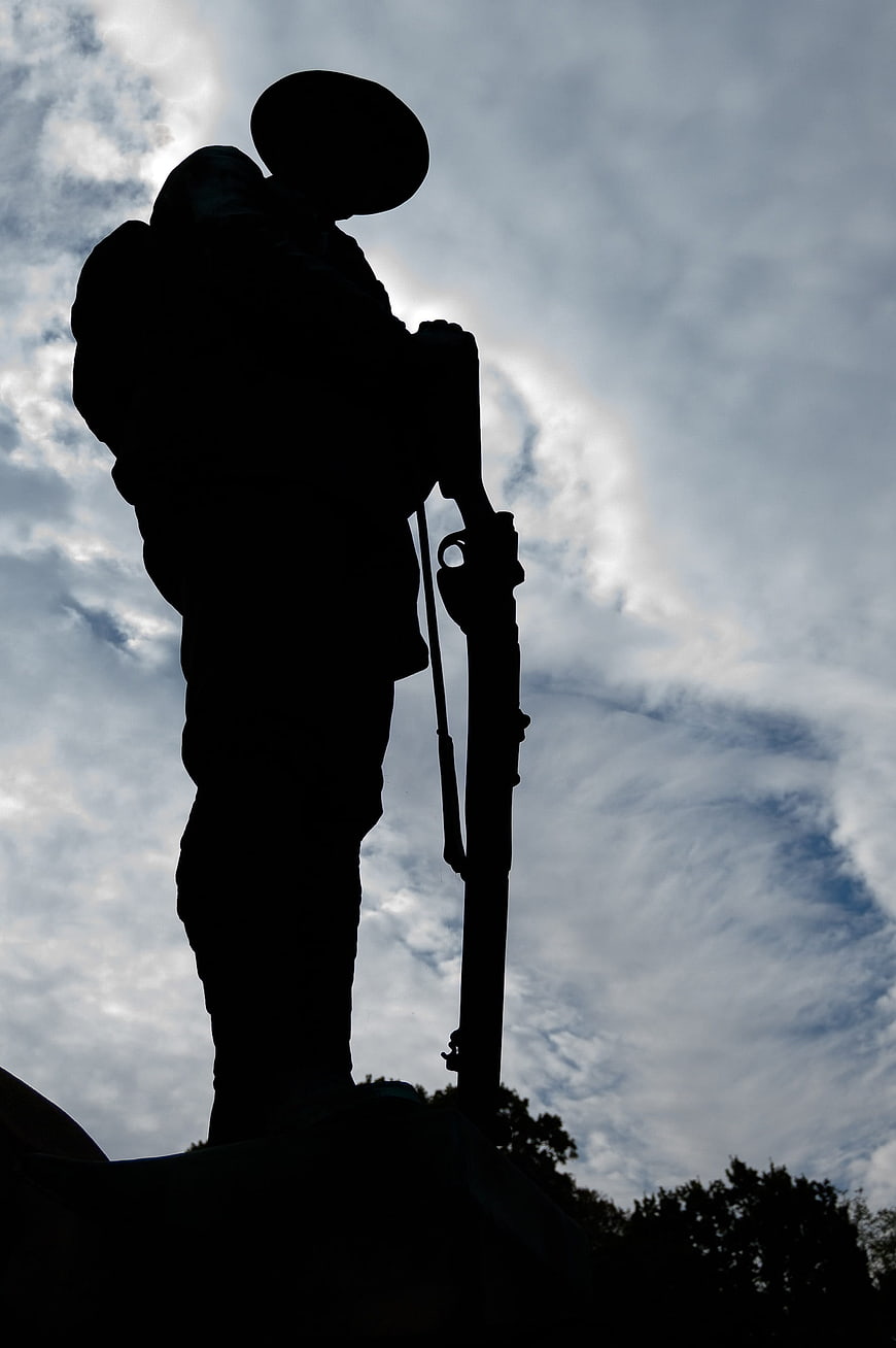 Silhouette of Soldier Statue Against Cloudy Sky