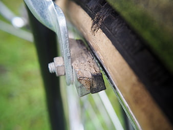 Close-up of worn bicycle brake pads on a muddy rim