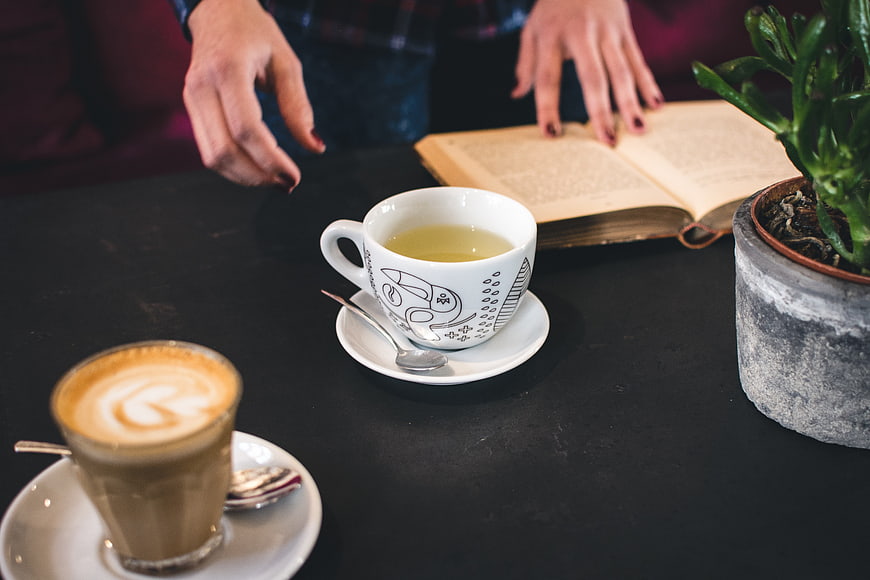 Cozy cafe scene with tea, coffee, and an open book