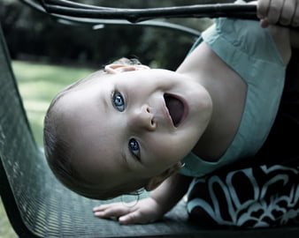 Happy Toddler Girl Looking Up from Swing