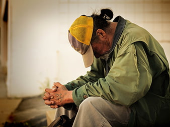 Homeless Man Sitting with Head Down in Prayer