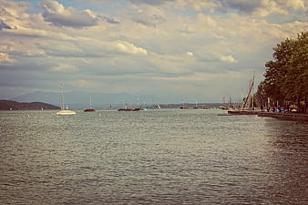 Sailboats on a Lake with Mountains and Cloudy Sky