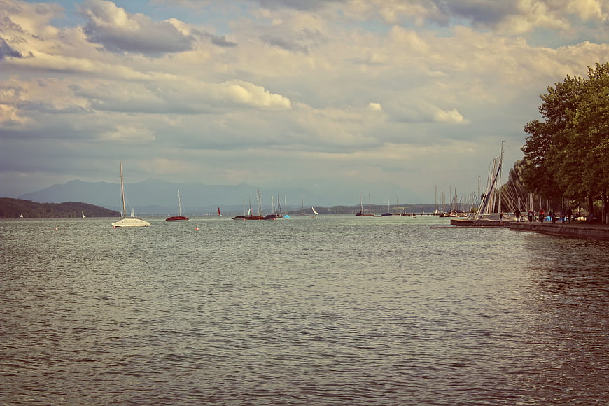 Sailboats on a Lake with Mountains and Cloudy Sky