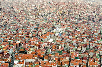 Aerial view of dense cityscape with red roofs and mosque