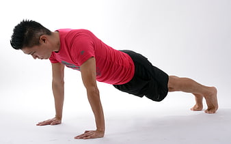 Asian man performing a push-up exercise in a red shirt