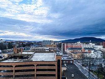 Dramatic Cloudy Sky Over Downtown Cityscape with Mountains