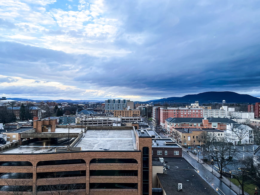 Dramatic Cloudy Sky Over Downtown Cityscape with Mountains