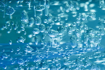 Close-up of rising water bubbles in blue liquid