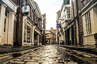 Low angle view of wet cobblestone street in historic English town