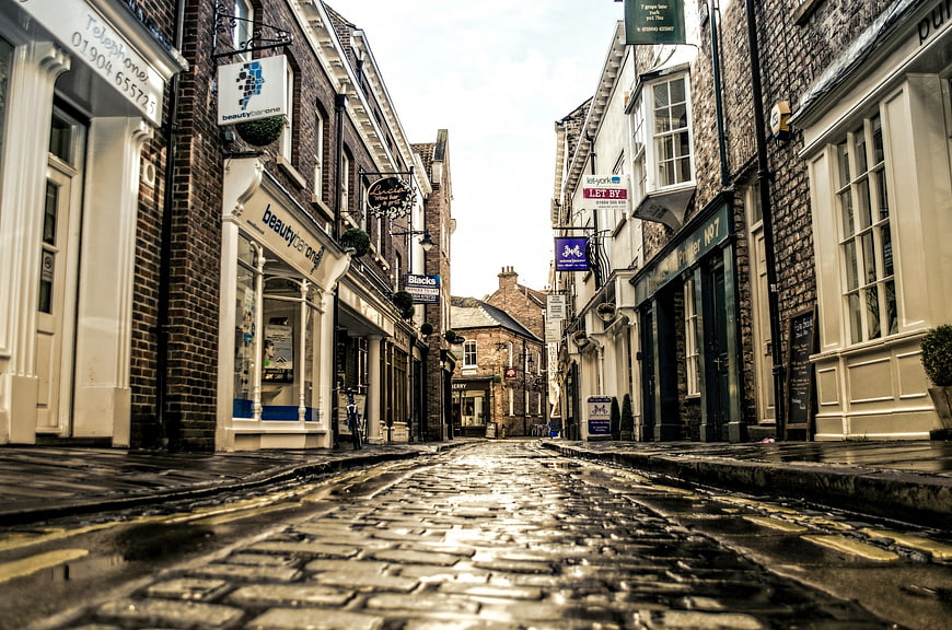 Low angle view of wet cobblestone street in historic English town