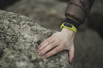 Close-up of hand with fitness tracker on rock