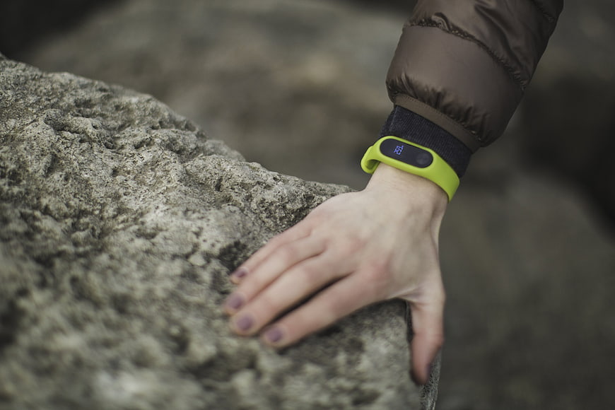 Close-up of hand with fitness tracker on rock