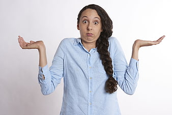 Confused woman shrugging with hands up against white background