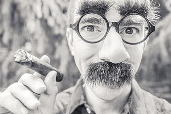 Man in Charlie Chaplin Costume Smoking Cigar