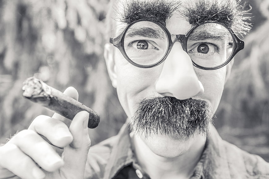 Man in Charlie Chaplin Costume Smoking Cigar
