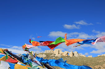Colorful Tibetan Prayer Flags Waving Against Blue Sky
