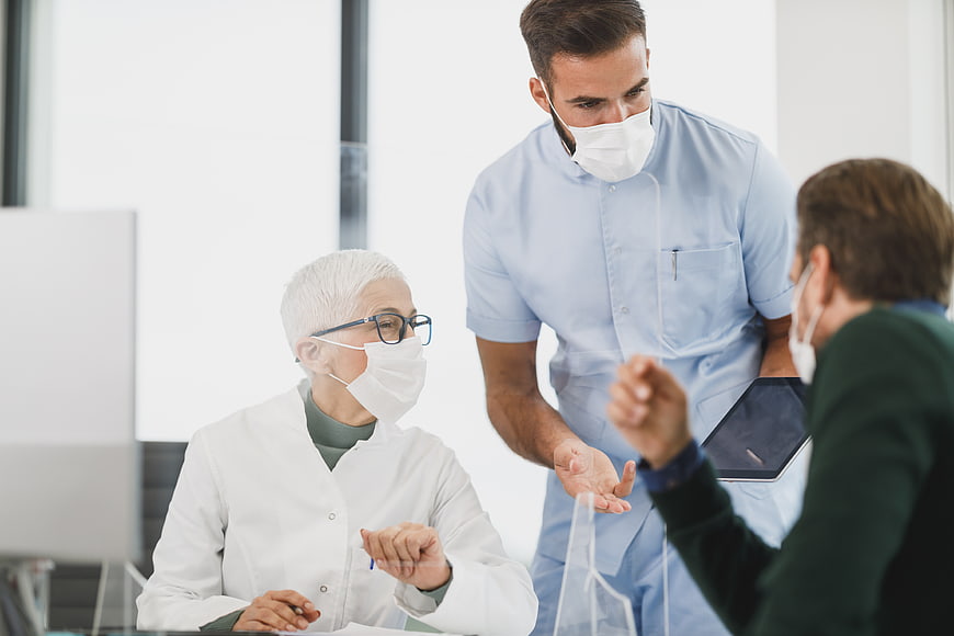 Medical team performing elbow bump greeting in clinic